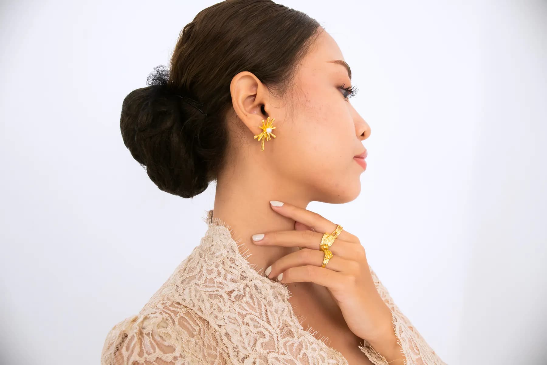 Profile of a model in a lace kebaya with a KILAU gold earring and ring