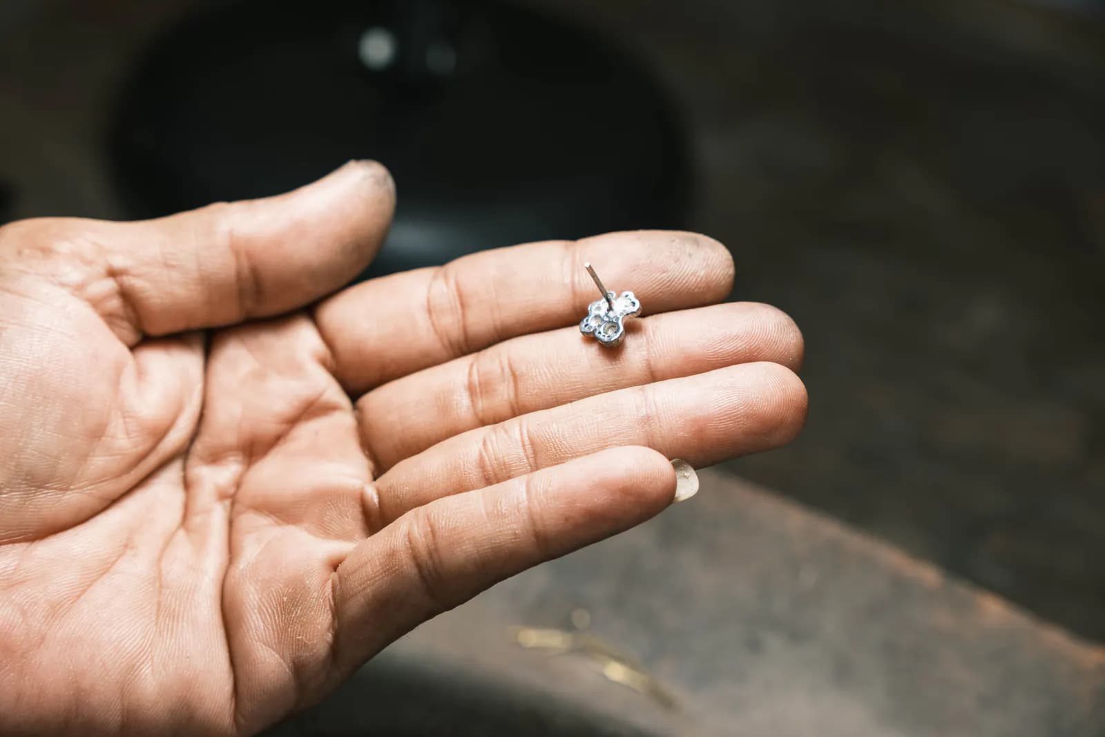 Open palm holding a small finished flower ring